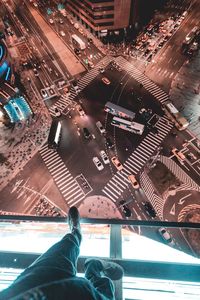 Low section of man standing on road in city