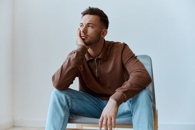 Portrait of young man sitting on sofa at home