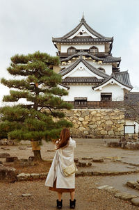 Rear view of woman standing against building