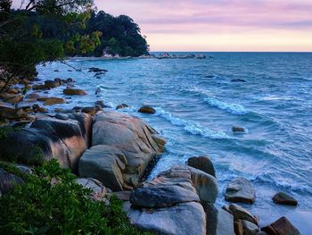 Scenic view of rocks on beach against sky