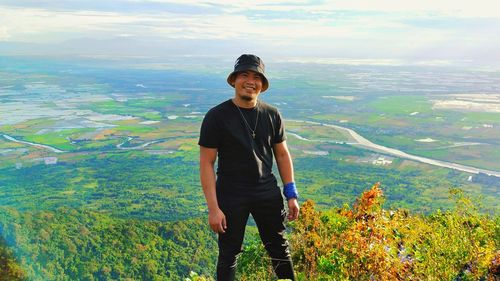 Portrait of smiling man standing against landscape