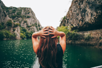 Rear view of woman on rock by lake