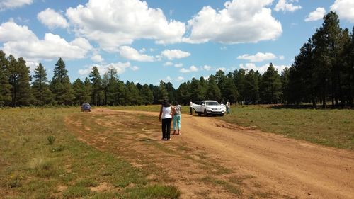 Rear view of man walking on dirt road