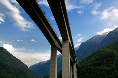 Low angle view of viaduct bridge and mountains against sky