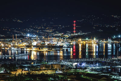 High angle view of illuminated city by river at night