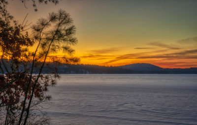 Scenic view of frozen lake against orange sky
