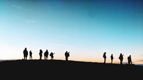 Silhouette people against clear sky during sunset