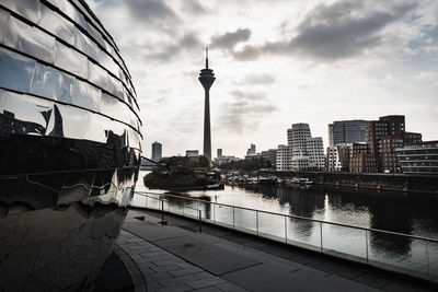 View of buildings in city against cloudy sky