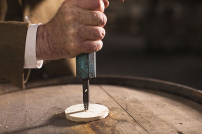 Close-up of man opening whiskey barrel