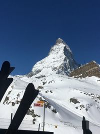 Scenic view of snow covered mountains against clear blue sky