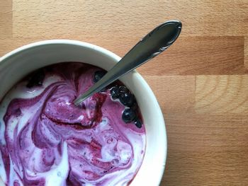 High angle view of blueberries and yogurt in bowl on table