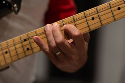 Midsection of man playing guitar