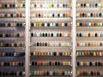 Full frame shot of colorful bottles on shelves for sale in store
