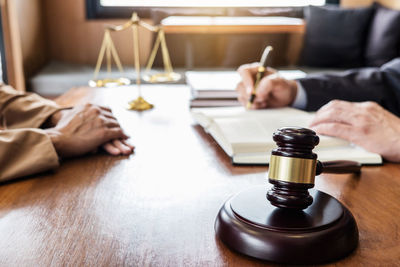 Midsection of lawyer with client in courtroom