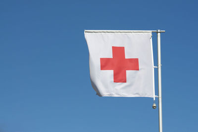Low angle view of flag against blue sky
