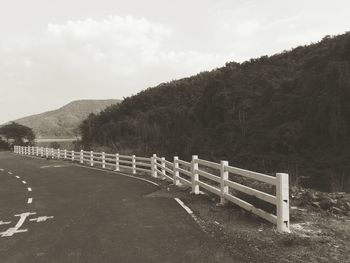 Road leading towards mountain against sky