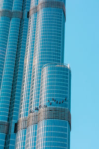 Low angle view of modern building against clear blue sky