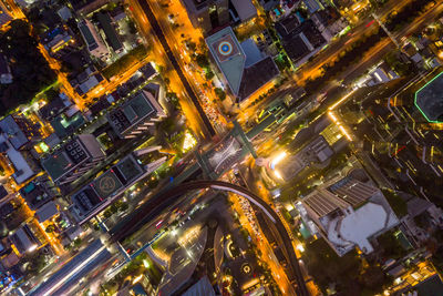 High angle view of illuminated street amidst buildings in city at night