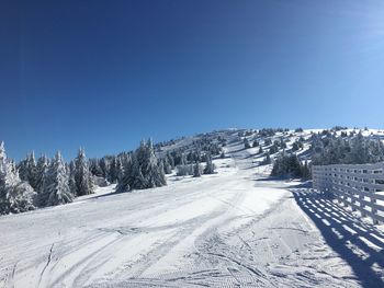 Scenic view of snowcapped mountains against clear blue sky