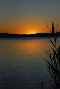 Scenic view of lake against clear sky at sunset