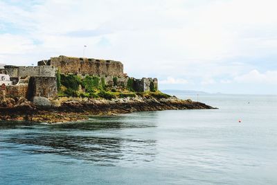 Scenic view of sea against sky with an old ruin 