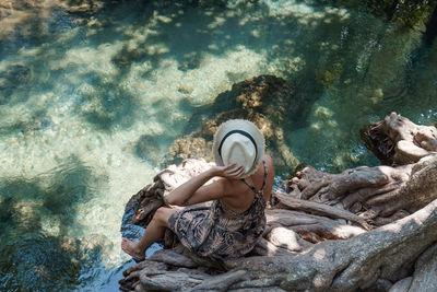 High angle view of woman relaxing next to crystal clear water