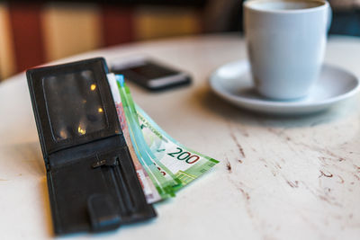 Close-up of paper currencies in wallet on table
