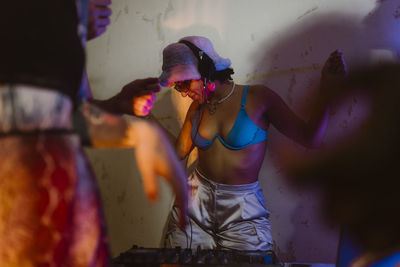 Carefree non-binary dj enjoying listening to music during party at nightclub