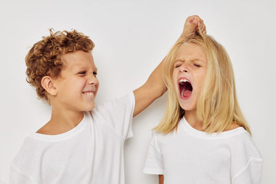 Siblings fighting against white background