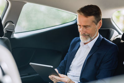 Man using mobile phone while sitting in car