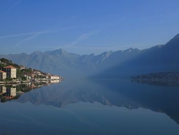 Scenic view of lake and mountains against blue sky