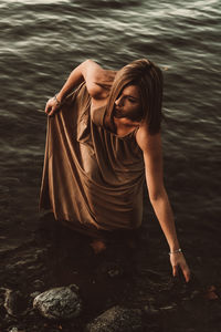 High angle view of woman sitting by lake