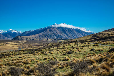 Scenic view of mountains against blue sky