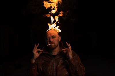 Portrait of senior man standing against black background