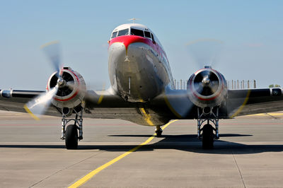 Dc-3 dakota on airport runway against sky