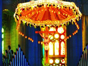 Low angle view of carousel hanging from ceiling at night