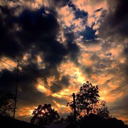 Silhouette of trees against cloudy sky