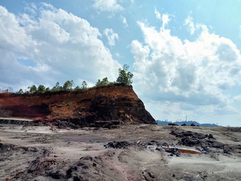 Rock formations on beach against sky