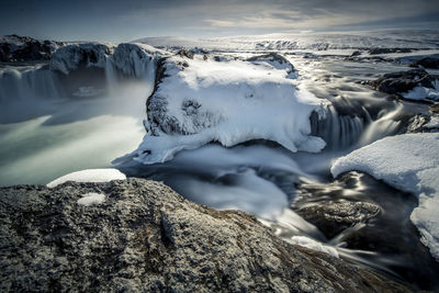 Scenic view of snow covered rock formations against sky