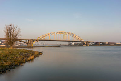 Arch bridge over river against sky