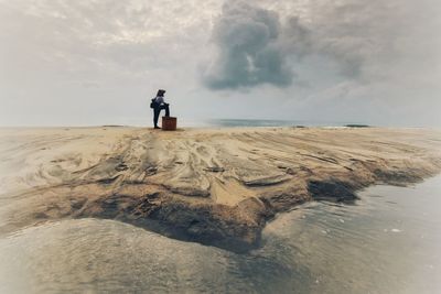 Digital composite image of man standing on beach