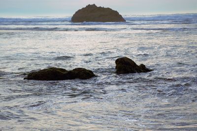 Rocks in sea against sky