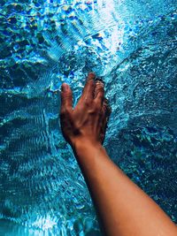 Low section of person swimming in pool