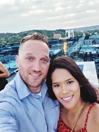 Portrait of smiling man and woman against sky