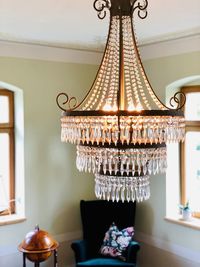 Illuminated chandelier hanging on table at home