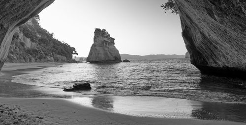 Rock formation on beach against clear sky