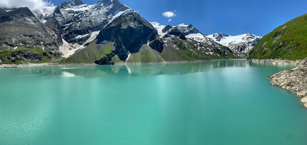 Scenic view of lake and snowcapped mountains against sky