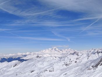 Scenic view of snowcapped mountains against blue sky
