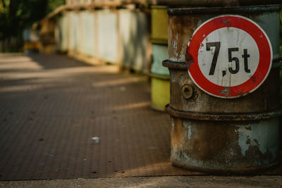 Close-up of old telephone booth on footpath
