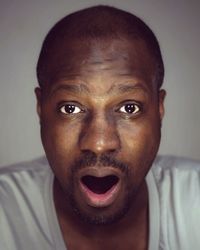 Close-up portrait of mature man with mouth open at home